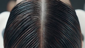 Close-up view of scalp with hair parted, Dr. Berg discusses usage, ingredients, and benefits.