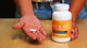 A person holds a capsule and D3 and K2 Vitamin bottle, while Dr. Berg explains benefits and ingredients.